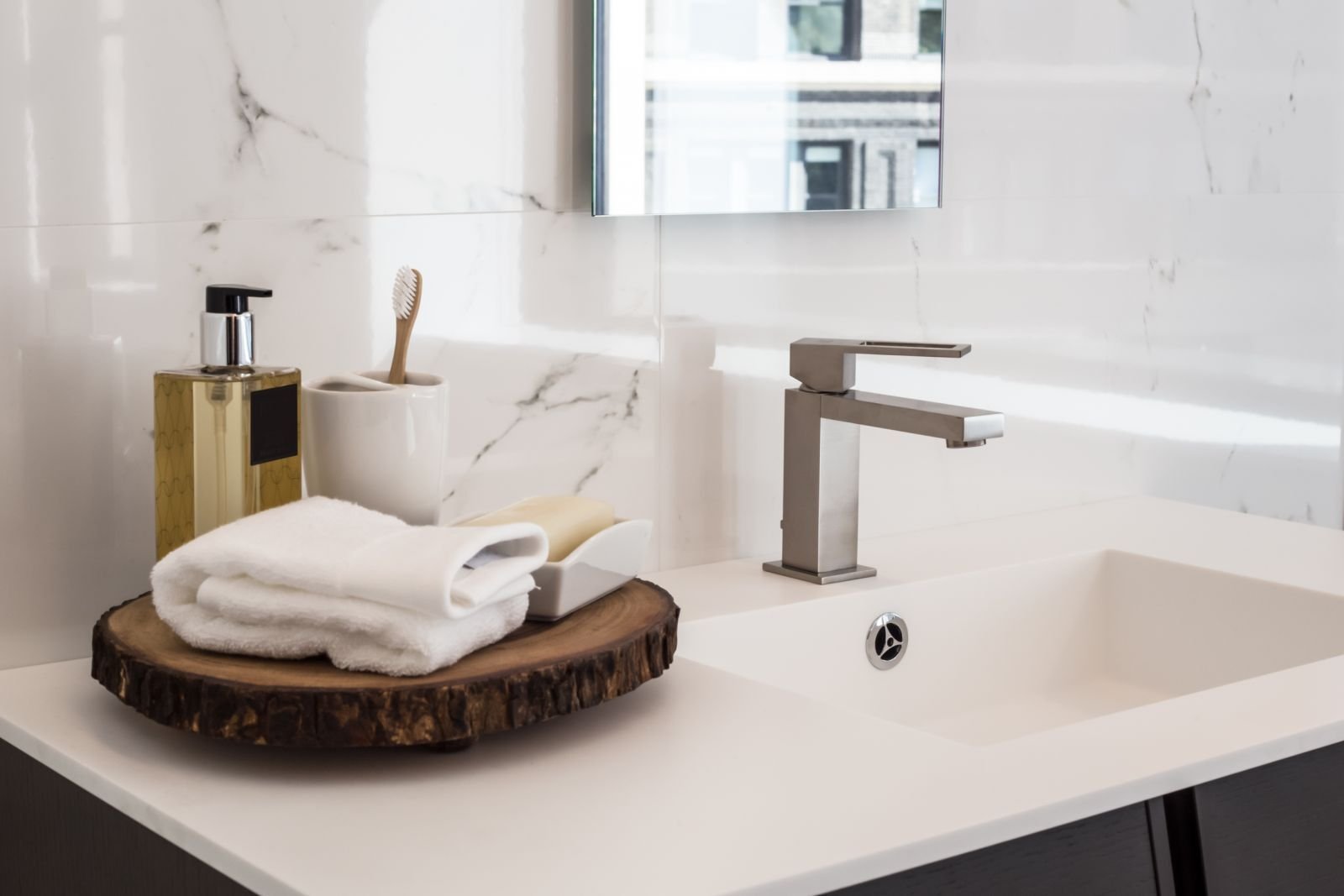 Badezimmer mit weißem Waschtisch und Metallarmatur