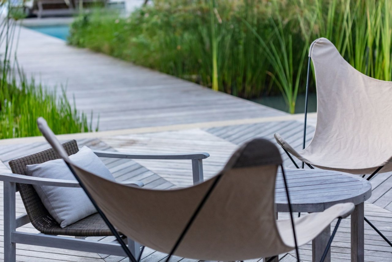Ruhige Terrassenszene mit Loungesesseln und Wasserblick Ruhige Terrassenszene mit Loungesesseln und Wasserblick