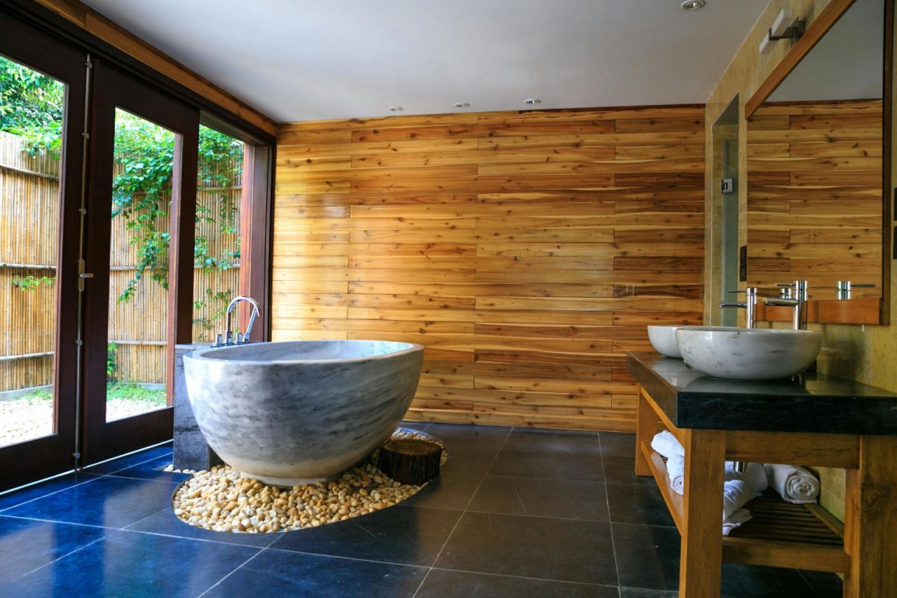 Badezimmer mit freistehender Steinbadewanne und Holzwand Badezimmer mit freistehender Steinbadewanne und Holzwand